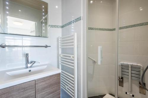 une salle de bain blanche avec un lavabo et une douche dans l'établissement Appartement les pieds dans l'eau pour 6 personnes à Saint-Raphaël, à Saint-Raphaël