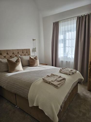 a bedroom with a large bed with towels on it at Blacksmiths Cottage in Brompton