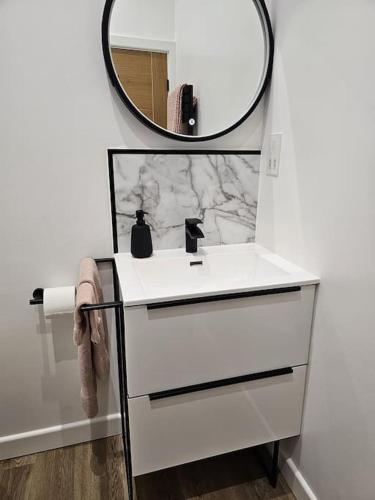 a bathroom with a white sink and a mirror at Blacksmiths Cottage in Brompton