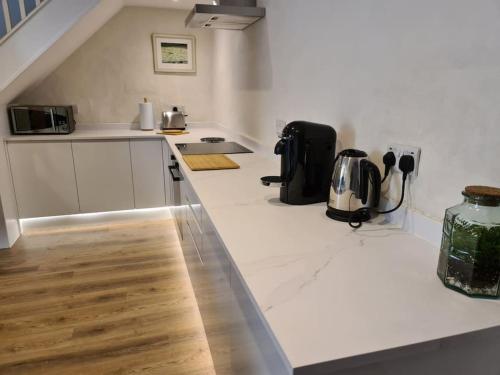 a kitchen with a white counter top with a appliance at Blacksmiths Cottage in Brompton