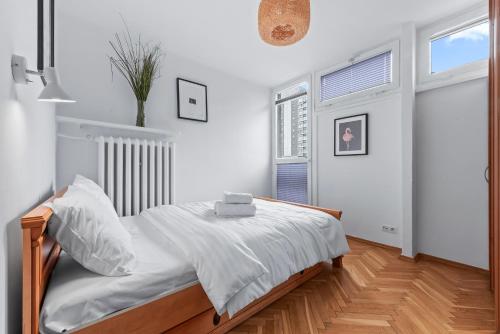 - une chambre blanche avec un lit et une fenêtre dans l'établissement RentPlanet - Apartament Mirów, à Varsovie