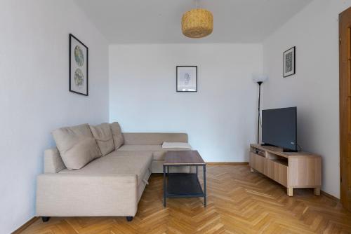 - un salon avec un canapé et une télévision dans l'établissement RentPlanet - Apartament Mirów, à Varsovie
