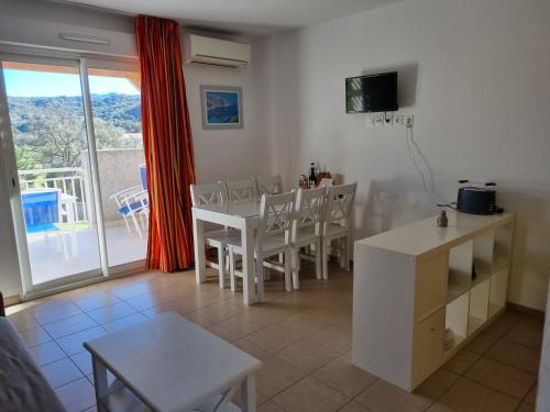 un salon avec une table et des chaises et un balcon dans l'établissement Résidence Saint Florent Oletta, à Saint-Florent