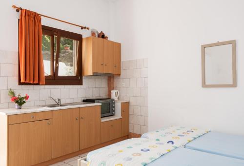 a small kitchen with a bed and a sink at Simeon Rooms & Apartments in Kamarai