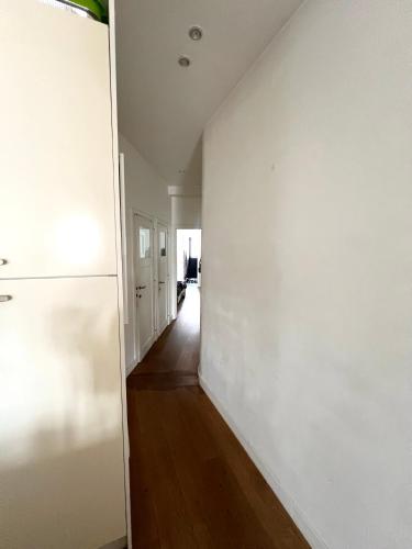 einen leeren Flur mit weißen Wänden und Holzboden in der Unterkunft Lumineux Haussmanien du Nord in Brüssel