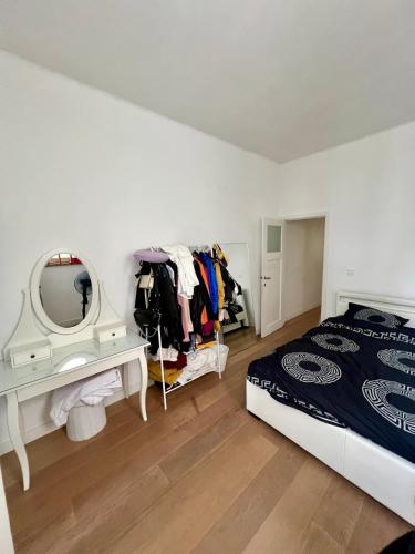 Schlafzimmer mit einem Bett, einem Schminktisch und einem Spiegel in der Unterkunft Lumineux Haussmanien du Nord in Brüssel