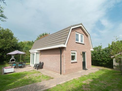 a small brick house with a patio in a yard at Nice house with large garden in Noordwijk and near the sea in Noordwijk aan Zee