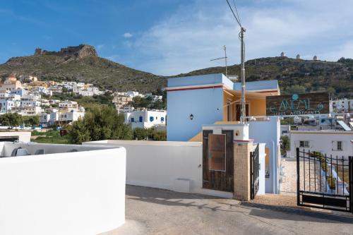 a white building with a sign in front of it at Anemi Leros Apartments 1 in Panteli