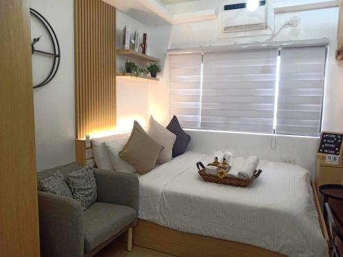 a bedroom with a bed and a couch and a window at ALABANG STUDIO unit w/ high speed Fiber WIFI in Manila