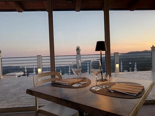una mesa con 2 copas de vino en el balcón en Tenuta Vallina - Golfo di Policastro en Tortorella