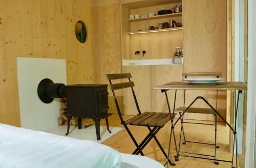 a room with a bed and a table and a chair at Tiny house u Dlouhé řeky in Buchlovice