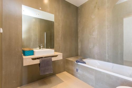 a bathroom with a tub and a sink and a bath tub at Villa Nooma in Carrapateira