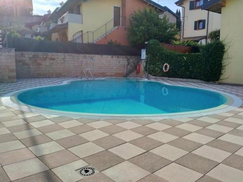 a swimming pool in a yard with a tiled floor at Villa Paola Relax in Colà di Lazise