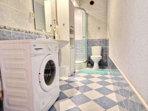 eine weiße Waschmaschine im Bad mit WC in der Unterkunft Apartmány Drážovce in Nitra