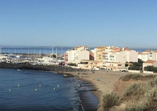 una playa con un montón de edificios en el agua en À 70 mètres de la plage, étage 1, en Cap d'Agde