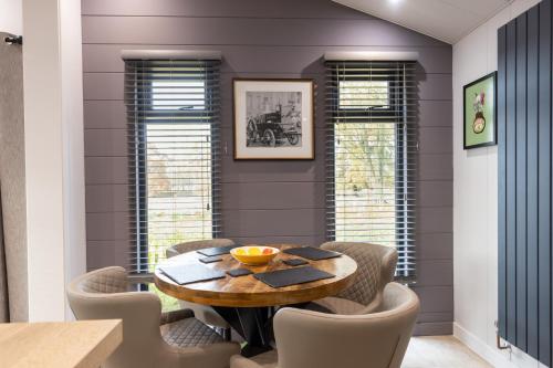 a dining room with a wooden table and chairs at Blenheim Palace Lodge Retreat in Woodstock