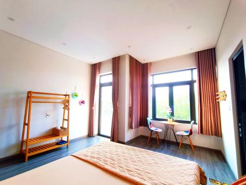 MyTran Homestay-HauLoan في كوي نون: غرفة نوم بسرير وطاولة مع كراسي