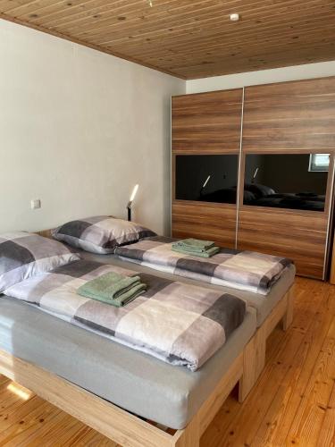 uma cama grande num quarto com pisos em madeira em Ferienwohnungen Schiffmann em Pressath