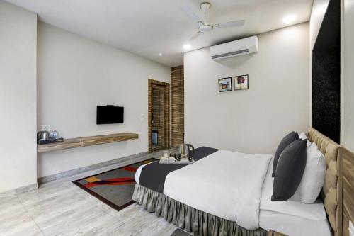 a hotel room with a bed and a tv at Townhouse OAK Shubhham Regency Near City Centre Salt Lake in Salt Lake City
