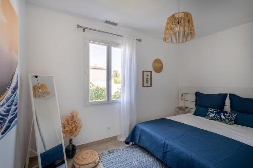 une chambre avec un lit bleu et une fenêtre dans l'établissement Villa de standing avec piscine dans le Var, à 10km des plages, à La Crau