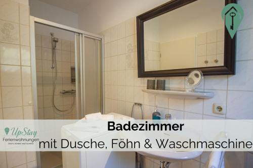 y baño con lavabo, ducha y espejo. en Ferienhaus Max, en Greetsiel
