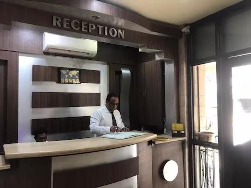 a man standing at a counter in an office at HOTEL GULSHAN INTERNATIONAL in Kolkata