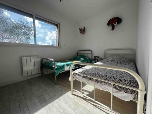 a room with two bunk beds and a window at La Villa Case-Bi in Saint-Germain-sur-Ay
