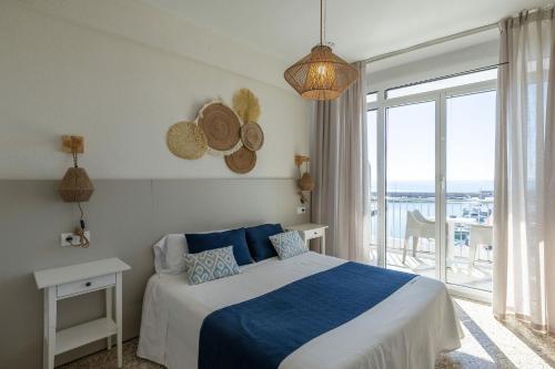 a bedroom with a bed with a view of the ocean at Hotel Ampolla Sol in L'Ampolla