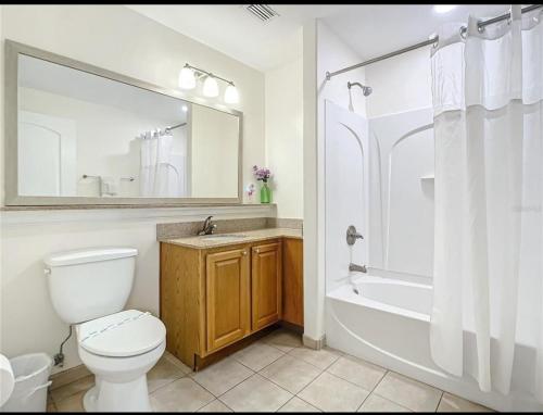 Un baño con inodoro, bañera y lavabo. en Blue Heron Beach Resort pet friendly, en Orlando