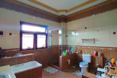 ein Bad mit einer Badewanne, einem WC und einer Dusche in der Unterkunft Bertam Villa Suites - Golf Resort by RZAC in Kepala Batas