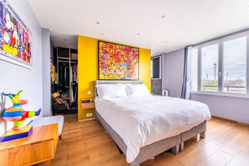 a bedroom with a large bed and a yellow wall at Sublime Appartement avec Terrasse in Charenton-le-Pont