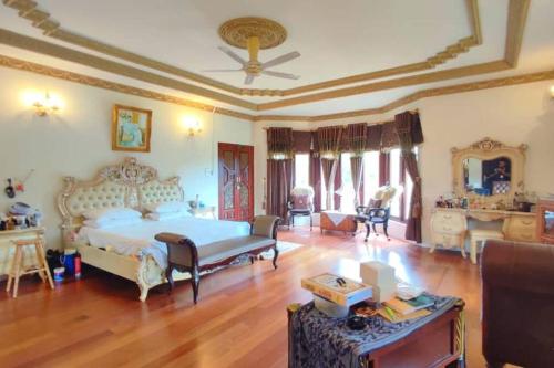 ein großes Schlafzimmer mit einem Bett und ein Wohnzimmer in der Unterkunft Bertam Villa Suites - Golf Resort by RZAC in Kepala Batas