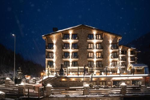 a large building with lights on it at night at Serras Andorra in Soldeu
