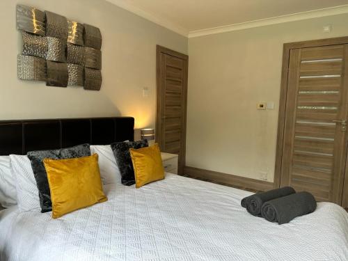 a bedroom with a bed with yellow and black pillows at A luxury double bedroom with ensuite in High Wycombe in Buckinghamshire