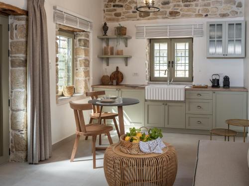 a kitchen with a table with a bowl of fruit on a stool at St-Ten Stone Built Village in Áyioi Dhéka