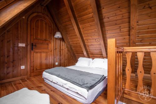 a bedroom with a bed in a wooden cabin at CASA REINA de Alma de Nieve in Tredós