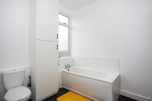 baño blanco con bañera y aseo en 3 Bedroom Apartment in Southchurch Village en Southend-on-Sea