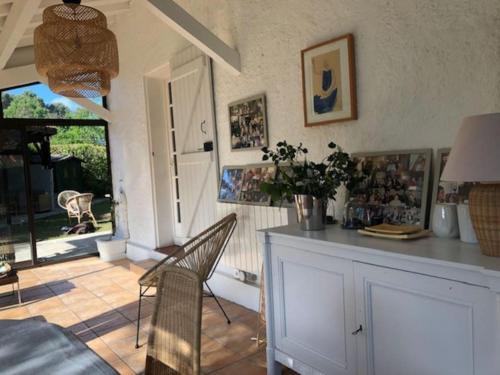 un salon avec une table et des chaises et une fenêtre dans l'établissement Villa landaise avec piscine, à Vielle-Saint-Girons