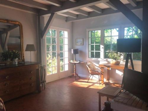 - un salon avec un bureau, des chaises et des fenêtres dans l'établissement Villa landaise avec piscine, à Vielle-Saint-Girons
