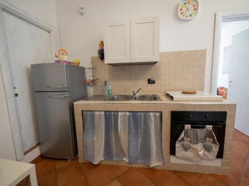 a kitchen with a sink and a refrigerator at Alloggio all’Ombra del Campanile in Riano