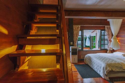 a bedroom with two bunk beds and a bed at Muangkham Cabin in Chiang Mai