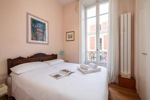 une chambre avec un lit blanc avec des serviettes dessus dans l'établissement Regina - Happy Rentals, à Menton