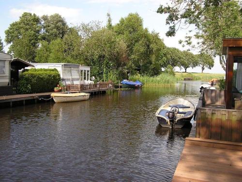 um pequeno barco está ancorado numa casa num rio em Luxury Holiday Home in Bantega with Harbour and Sloop em Bantega