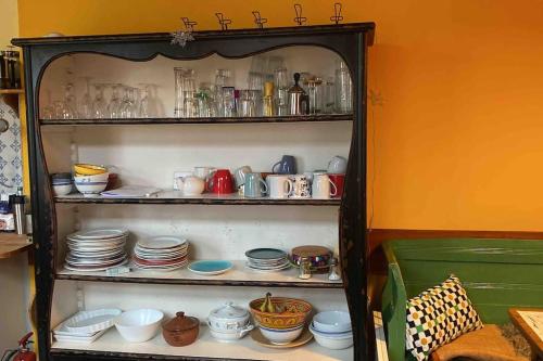 ein Regal voller Schüsseln, Tassen und Teller in der Unterkunft Vierländer Hippiehof in Hamburg