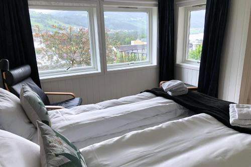two beds sitting in a room with windows at Store Ringheim Apartment - Villa Solberg in Vossevangen