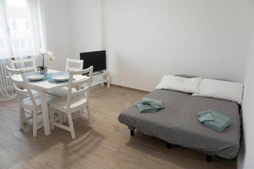um quarto com uma mesa e uma cama e uma mesa e cadeiras em Casa Zaffiro em Savigliano