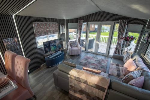 an aerial view of a living room with a couch and chairs at Tattershall VIP Retreat - Hot tub, stunning lakeside views, newly refurbished to an amazing 5 star standard in Tattershall