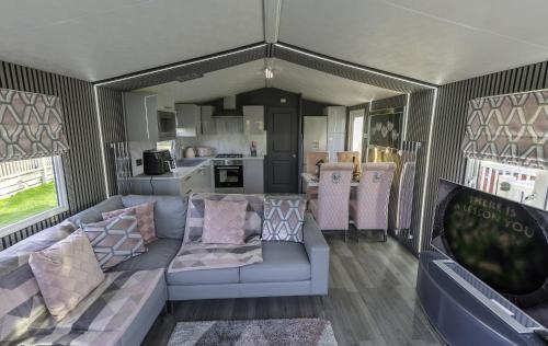 an rv living room with a couch and a kitchen at Tattershall VIP Retreat - Hot tub, stunning lakeside views, newly refurbished to an amazing 5 star standard in Tattershall