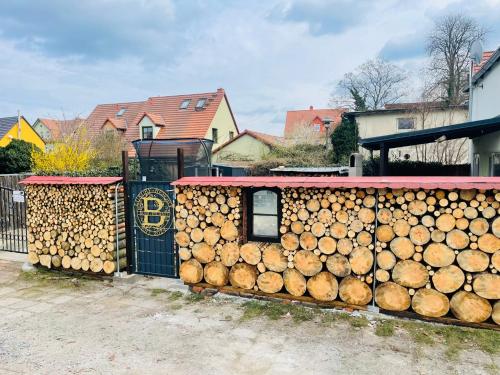 a pile of logs in front of a fence at Buri`s Seenlandhaus in Hoyerswerda