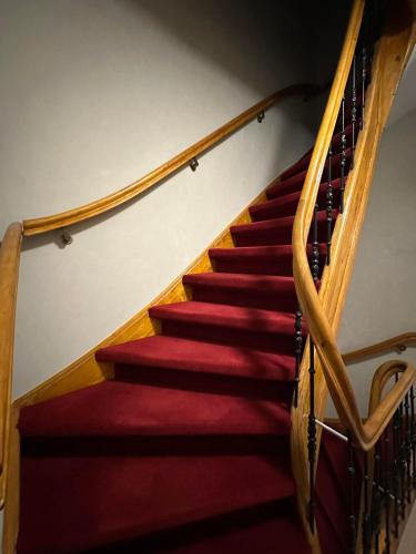 a staircase with red carpet and wooden rails at Voyagers Amsterdam in Amsterdam